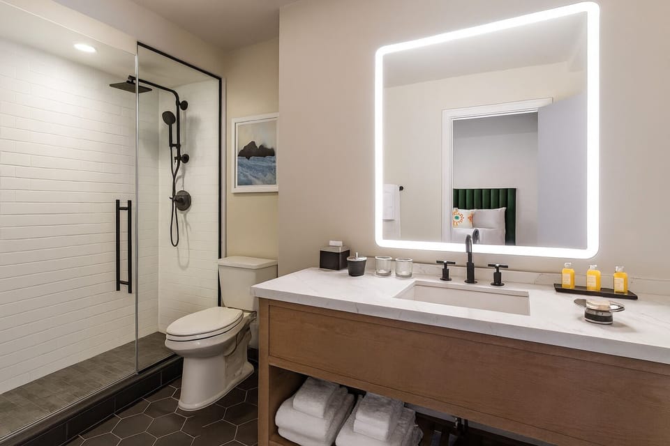 Refresh under a spa-style shower with bright vanity lighting.