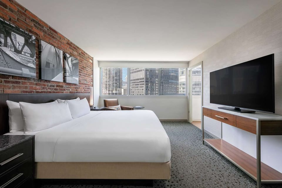 Relax into crisp linens beside exposed brick and a wide window.