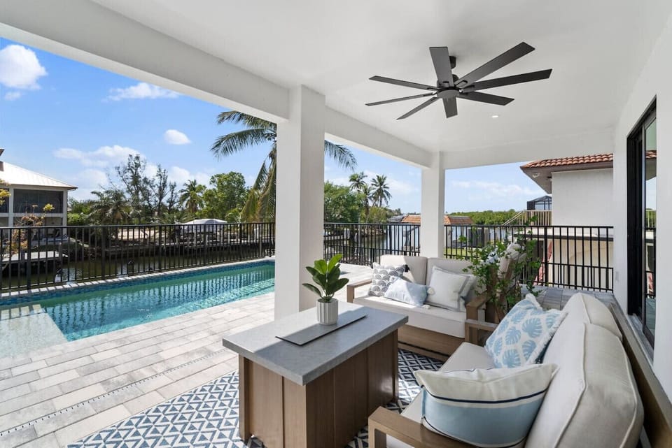 Lounge in the shade with pool views and the breeze off the bay
