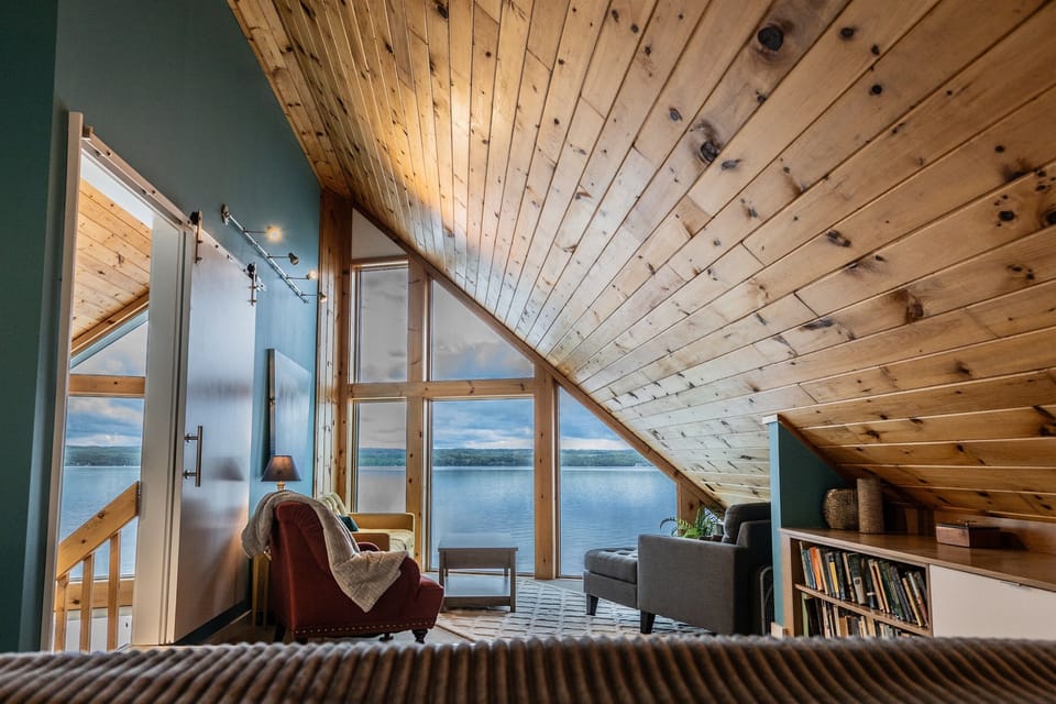 Wake up to panoramic lake views through floor-to-ceiling windows in the top-floor king suite—your private retreat with unmatched scenery from the comfort of bed.