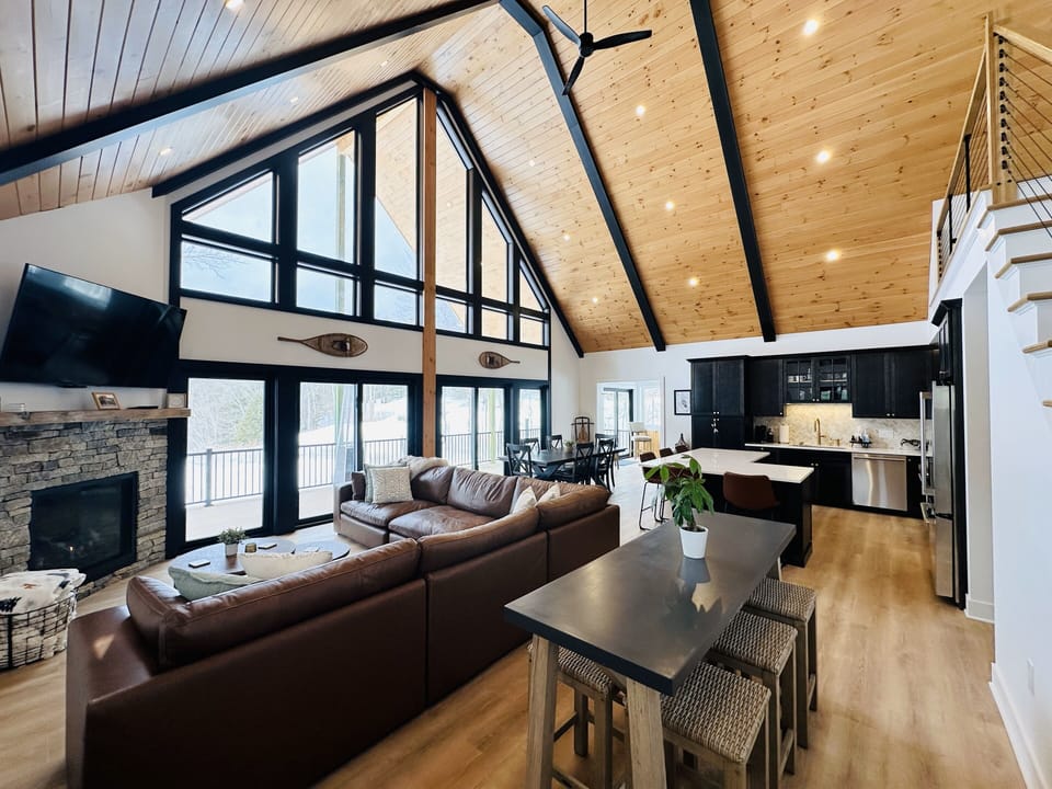 Open floor plan features floor-to-ceiling windows and vaulted ceiling. 