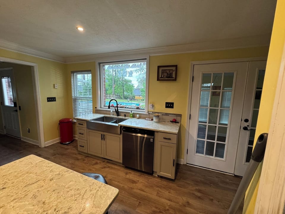 Downstairs Kitchen Dishwasher and Sink and closet and Picture Window to Backyard