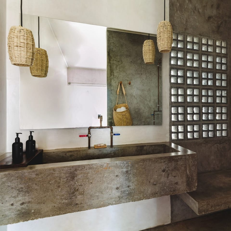 Refresh at the sculpted concrete vanity with soft ambient lighting.
