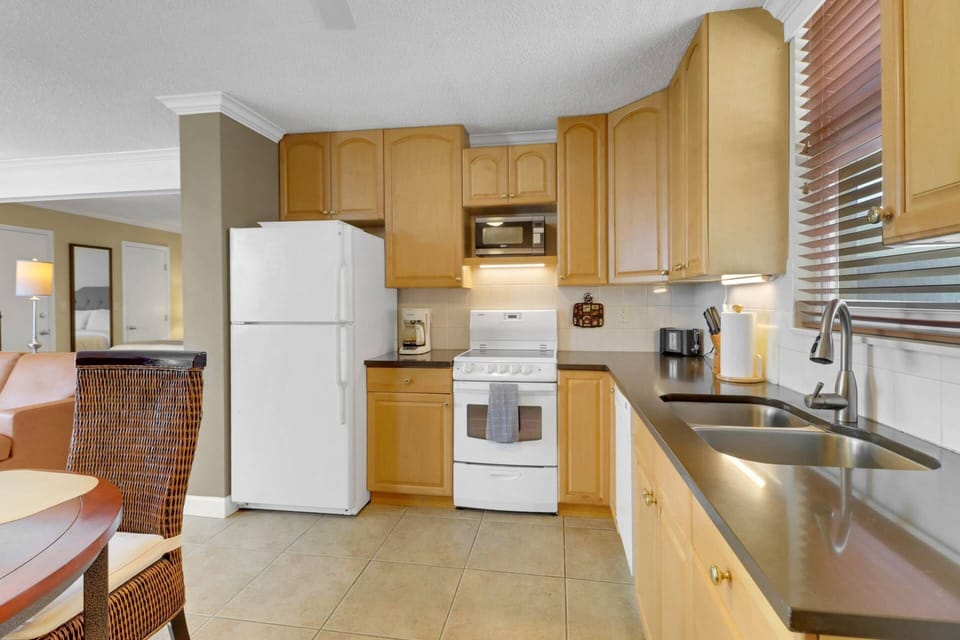 The kitchen is equipped with oven, microwave, refrigerator/freezer and compact dishwasher.