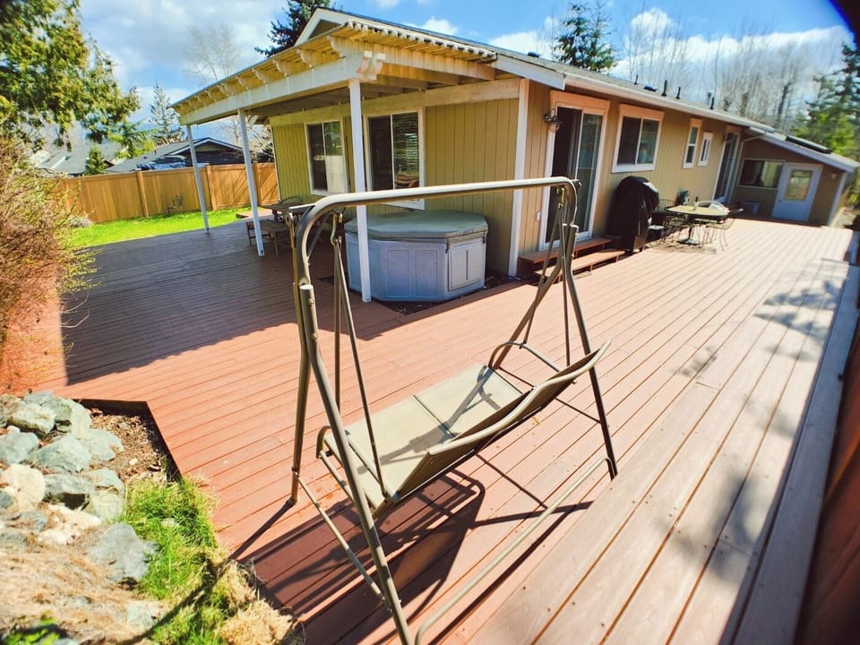 Swing, hotub, large deck and deck bench.