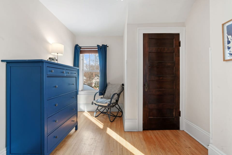 Unpack in your bright bedroom with a charming blue dresser and cozy reading nook by the window.