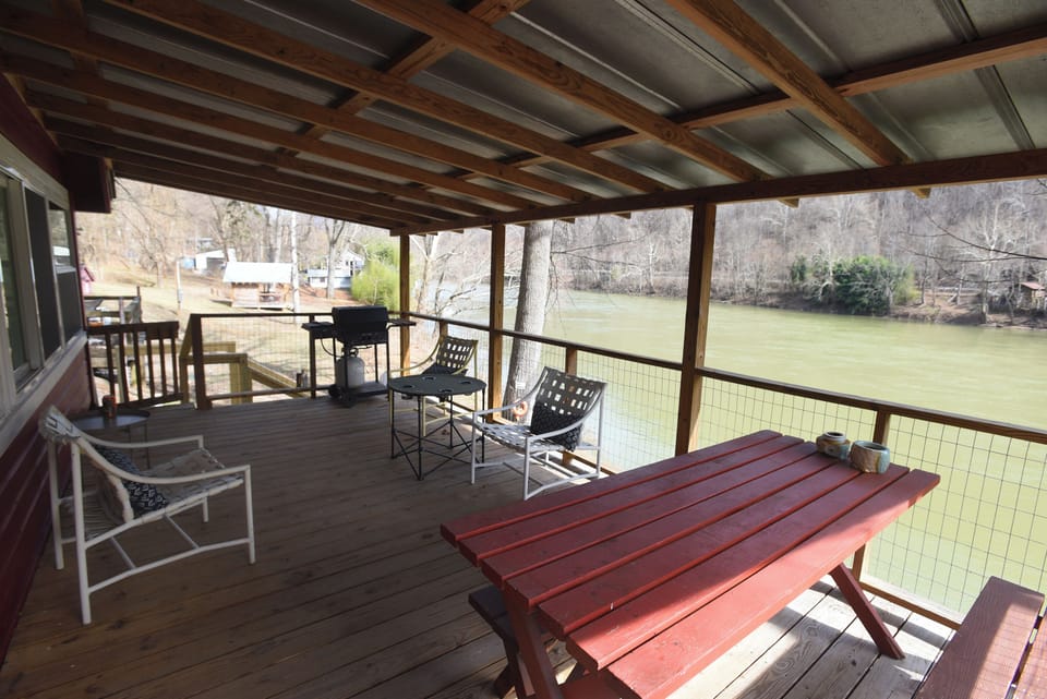Covered deck with a grill for cooking burgers or dogs and beautiful view .