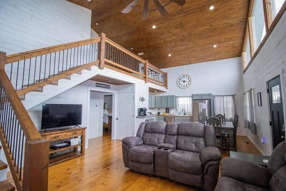 Open-concept living room with cozy seating, streaming-ready TV, board games and a dedicated workspace—ideal for families and remote work.