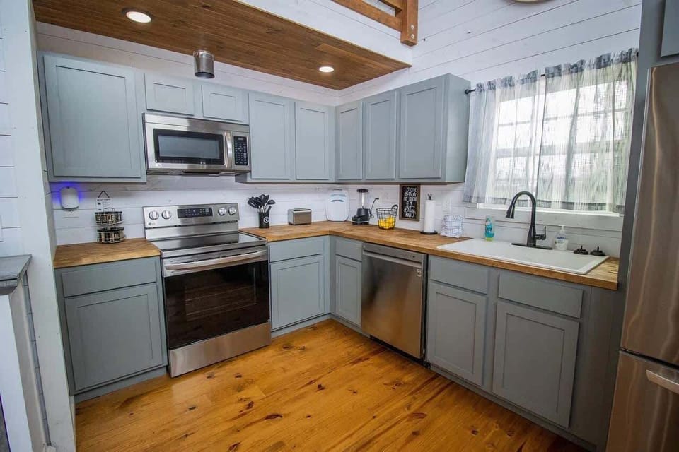 A haven of modern simplicity. Sleek appliances, calming greys, and a warm wood floor create a tranquil culinary space