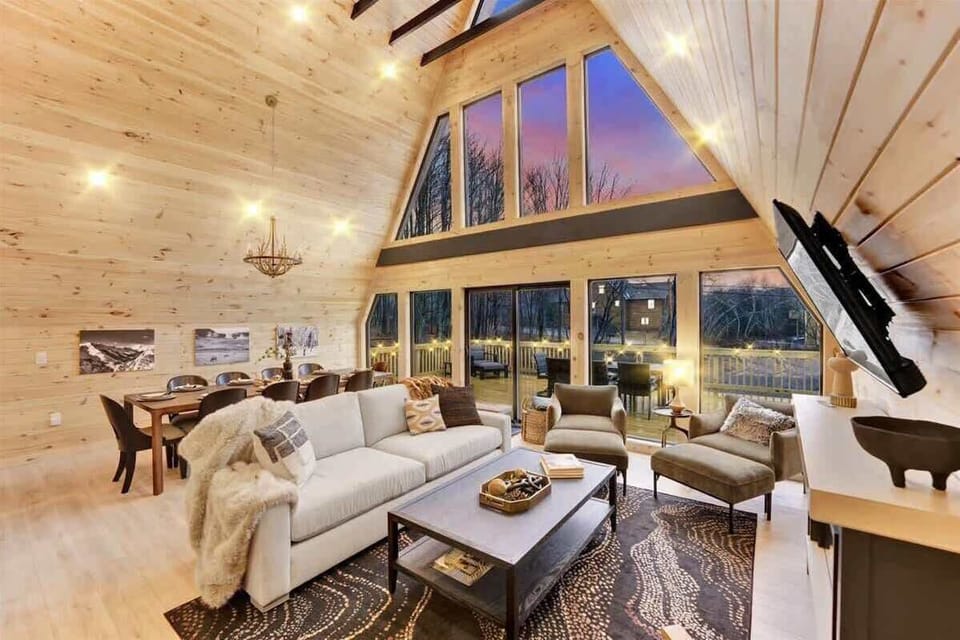 Luxury living room with soaring ceilings, fireplace, and natural light