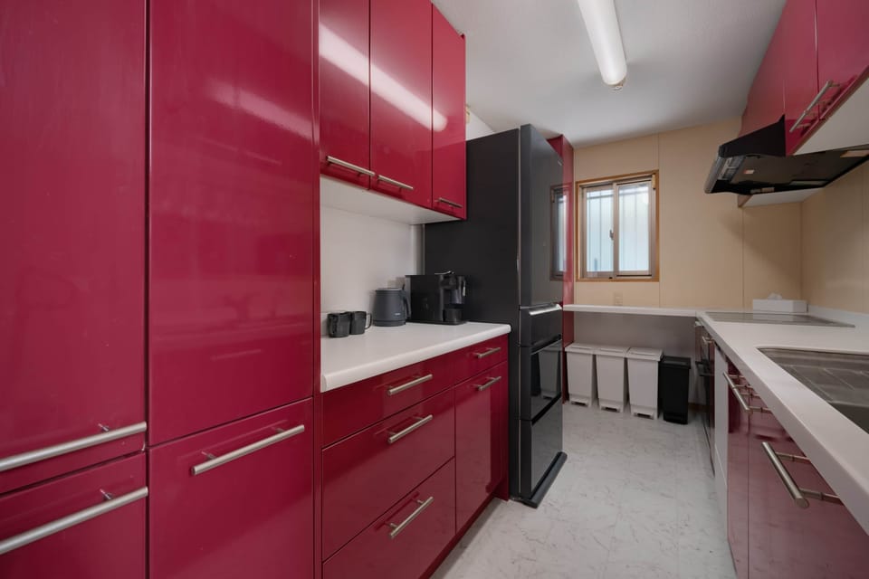 A stylish and functional kitchen with bold red cabinets, perfect for home-cooked meals for family
