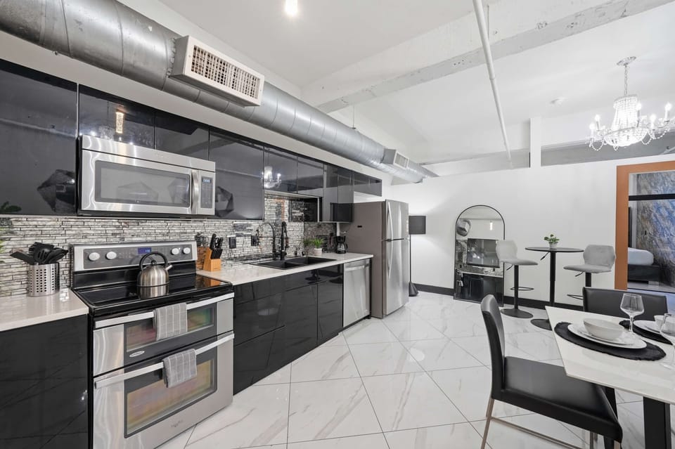 Sleek kitchen with stainless steel appliances and bar seating.