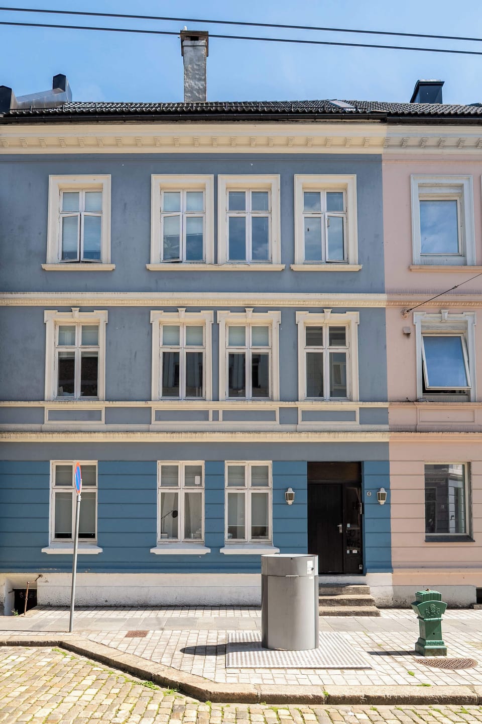 Charming exterior of a traditional Norwegian building with soft blue facade