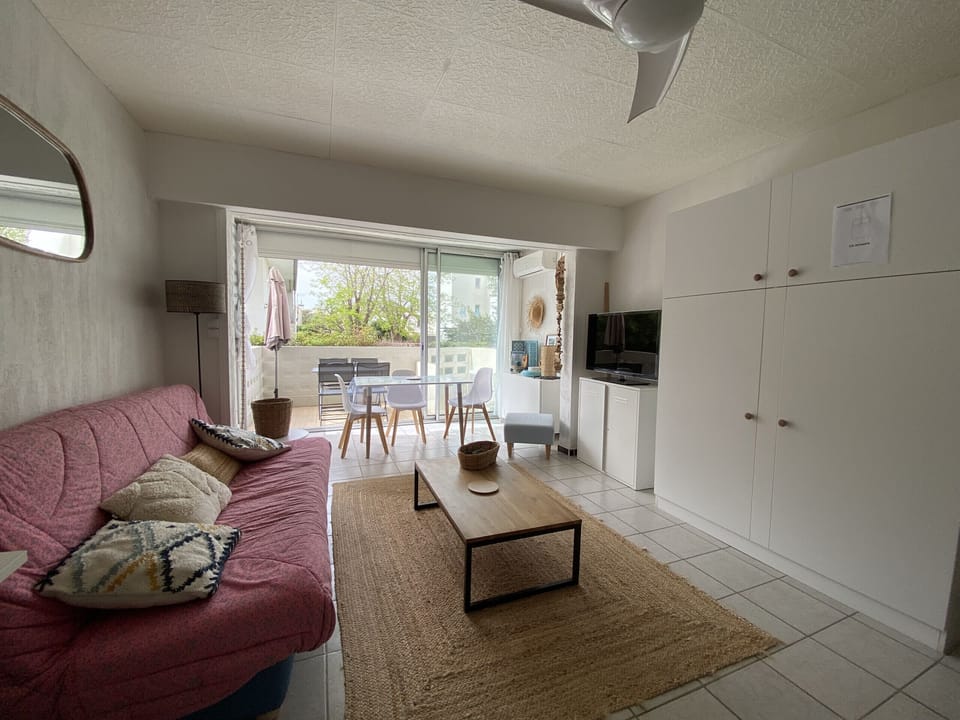 Bright living room, open to a terrace, combines a cozy sitting area and dining area