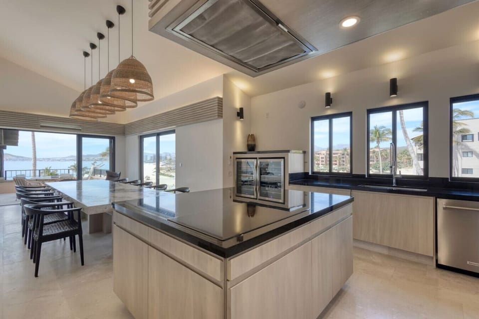 Modern kitchen with large island and pendant lights.