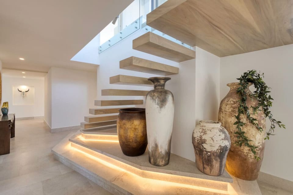 Staircase with large vases – Floating stairs accented with rustic pottery.