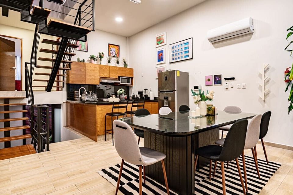 Open-concept kitchen and dining area, featuring modern appliances and sleek decor