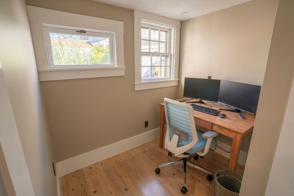 Office that includes a dock, dual monitors, webcam, keyboard and mouse. 
