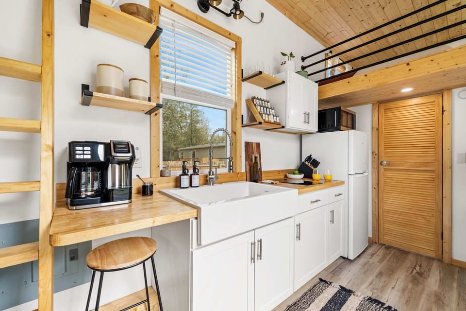 Sleek tiny home kitchen complete with a coffee station and essentials.