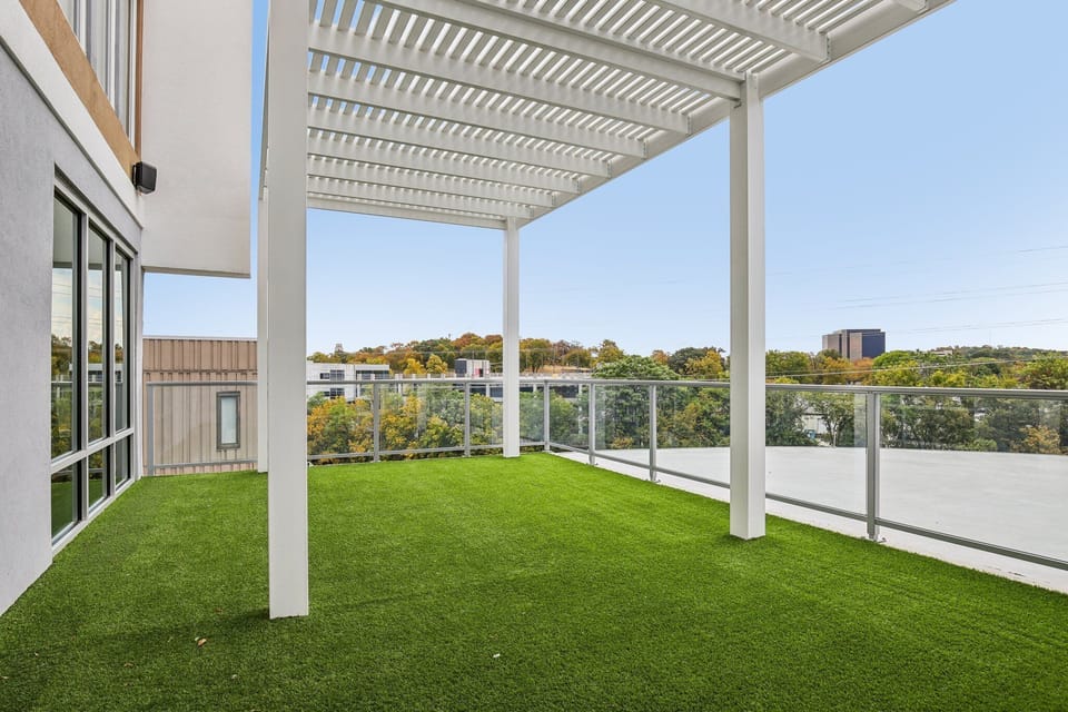 Spacious rooftop terrace with green turf and skyline views—ideal for relaxing, yoga, or catching fresh air between work sessions in Nashville.