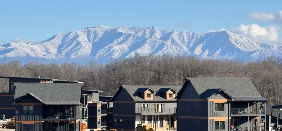 Modern buildings with snow-covered mountain views in the background