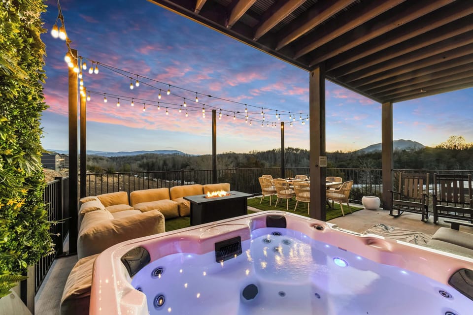 Relax in the outdoor hot tub while enjoying mountain views and a cozy fire pit at sunset.
