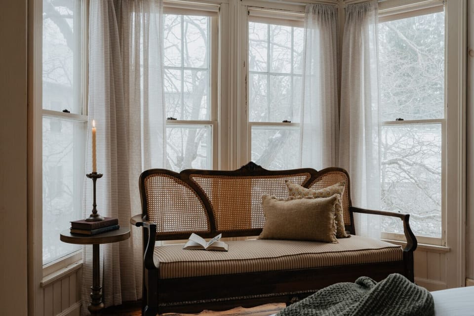 A bright and tranquil reading nook in the Dickinson Room, where you can curl up with a book and enjoy the soft natural light streaming through the bay windows.