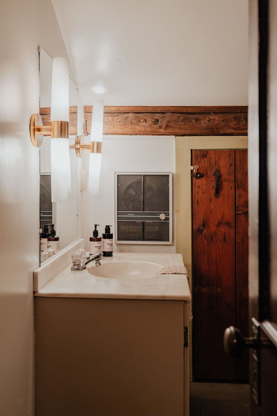 The Fitzgerald Room’s private bathroom, located across the hallway, features a spacious vanity, elegant lighting, and rustic charm. Reserved exclusively for guests of this room.