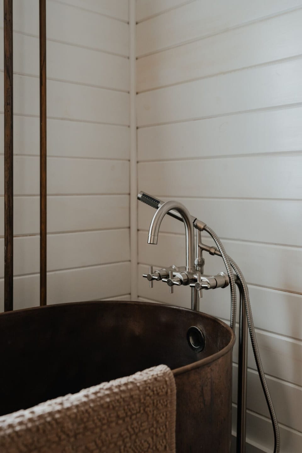 Elegant Vintage Bathtub Details – The gleaming brass fixtures and rich patina of the copper tub create a luxurious and inviting bath experience, perfect for a soothing soak.