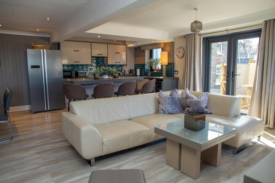 Lounge area with large sofa and doors leading to the patio area