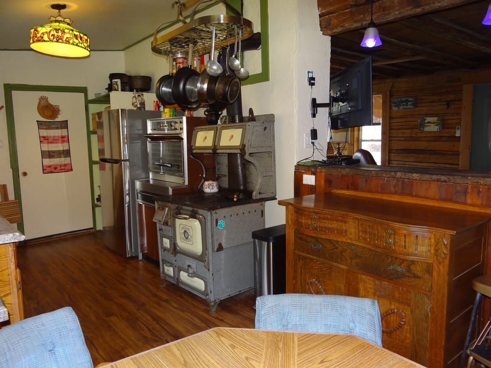 Refrigerator, vintage stove, and antique wood burning stove (show only).