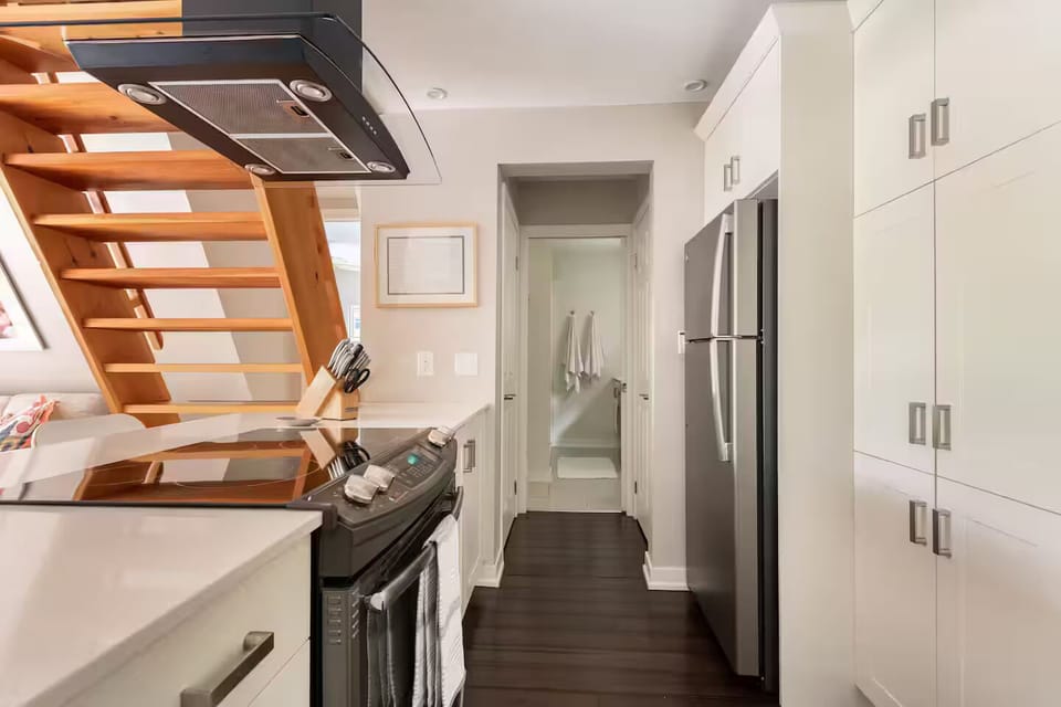 Kitchen fridge, pantry and peninsula, and entrance to main floor full bathroom.