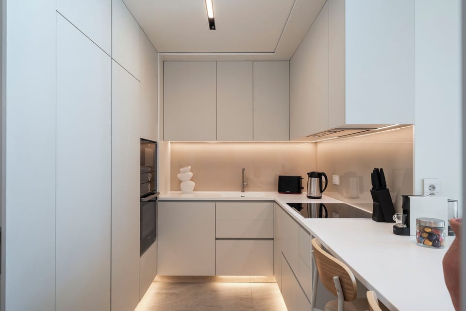 White kitchen units with oven, microwave, stove and other utensils