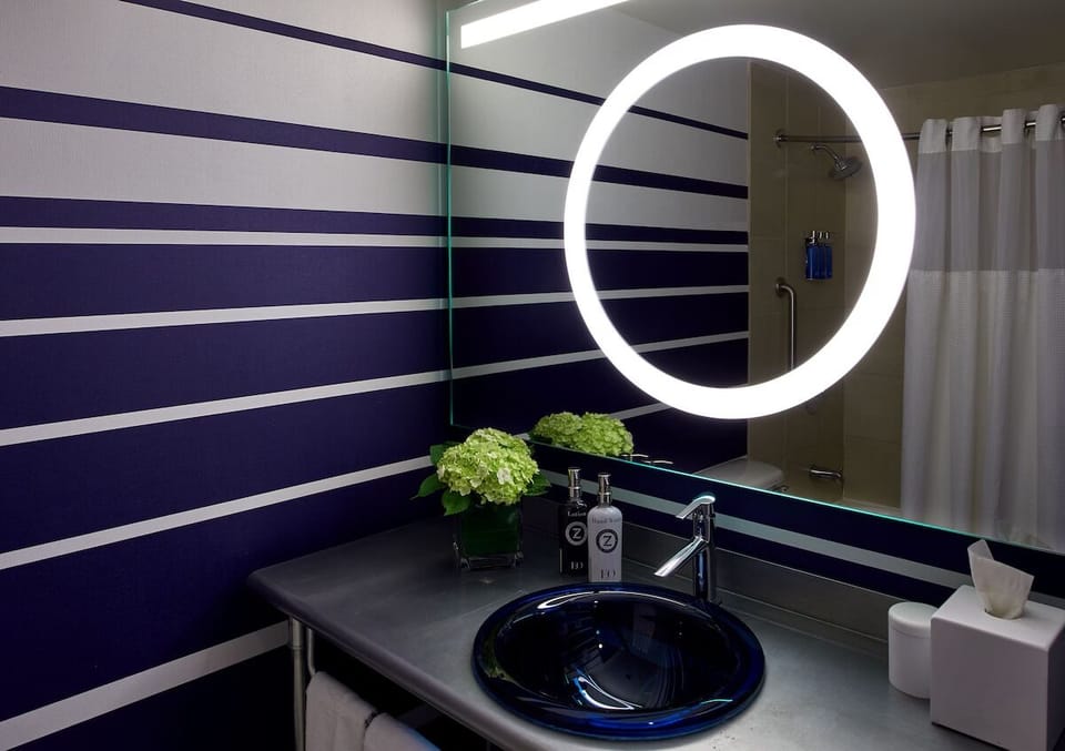 Refresh under a warm shower beside a glowing modern mirror.