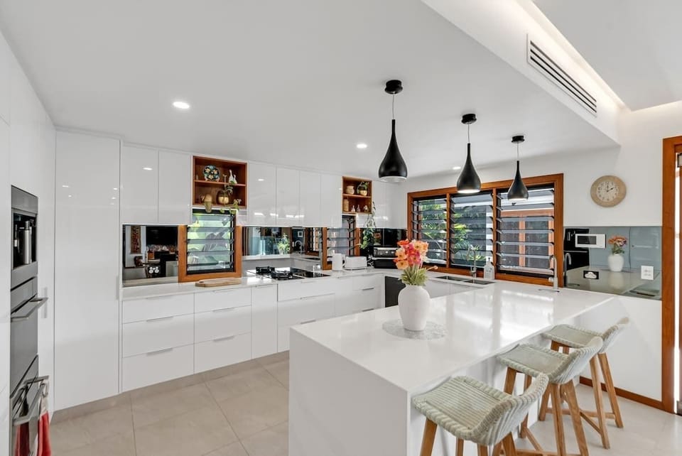 Cook and connect in the gourmet kitchen, equipped with top-of-the-line appliances, a spacious bench, and elegant pendant lighting.
