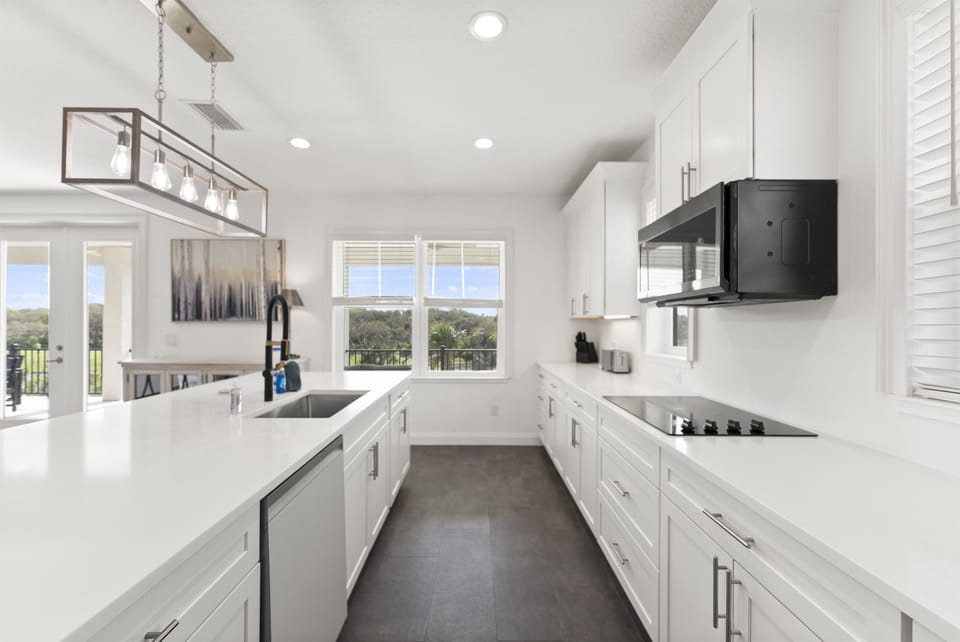 Bright fully equipped kitchen designed for cooking meals together with modern appliances and ample counter space
