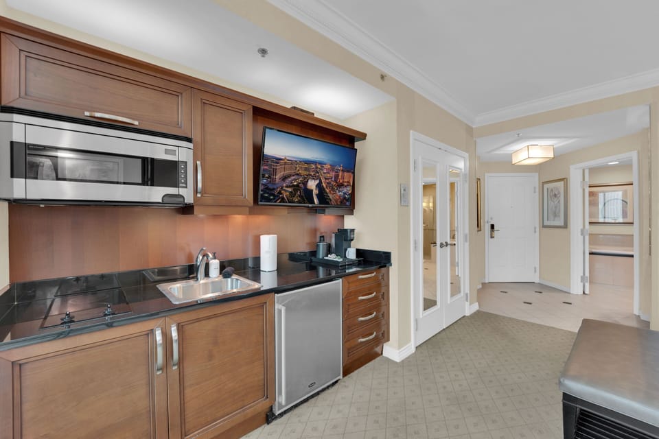 Fully equipped studio kitchen with a mini fridge, cooktop, microwave, and coffee maker.