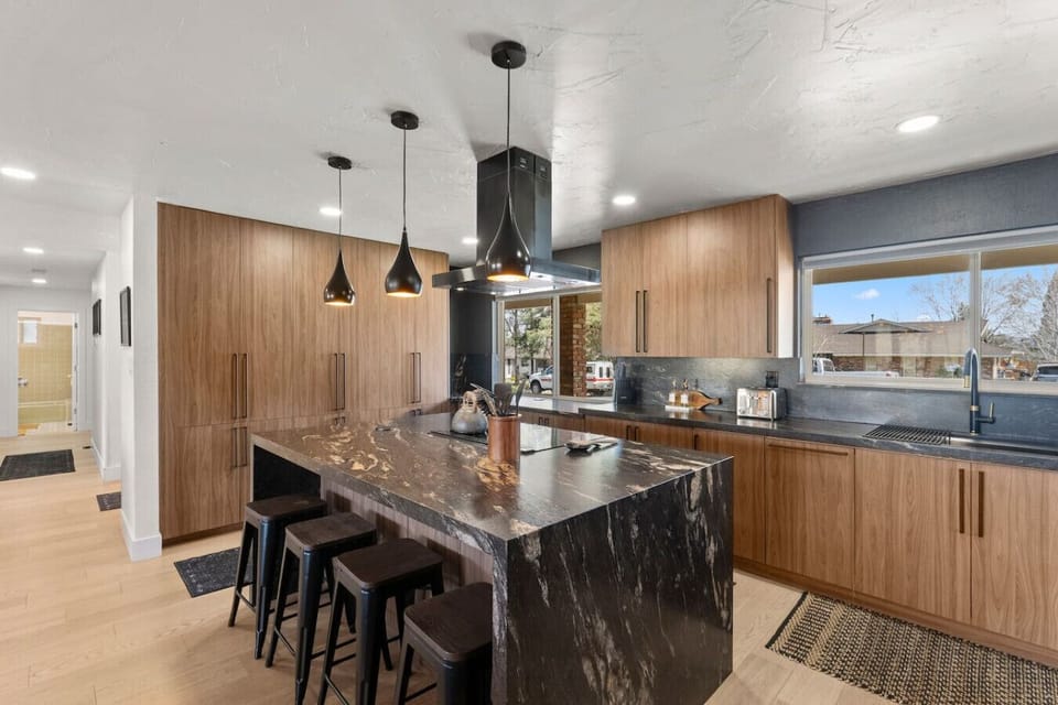 Cook, gather, and make memories in this stunning modern kitchen! With sleek wood cabinetry, a waterfall island, and top-notch appliances, this space is perfect for everything from morning coffee to gourmet meals.