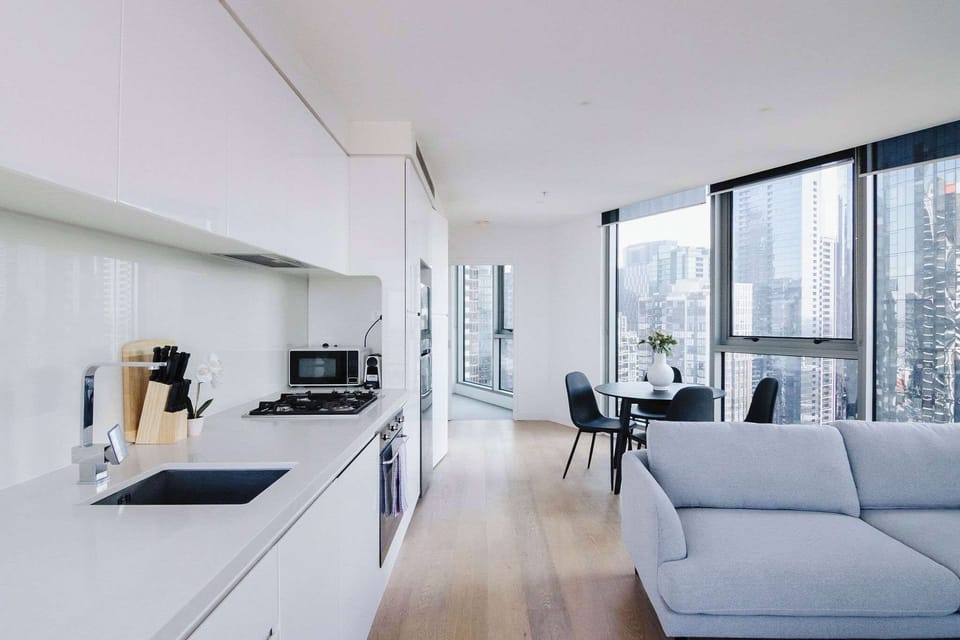 Open plan kitchen with cooking utensils, Nespresso coffee machine, dishwasher, oven and stove top. 