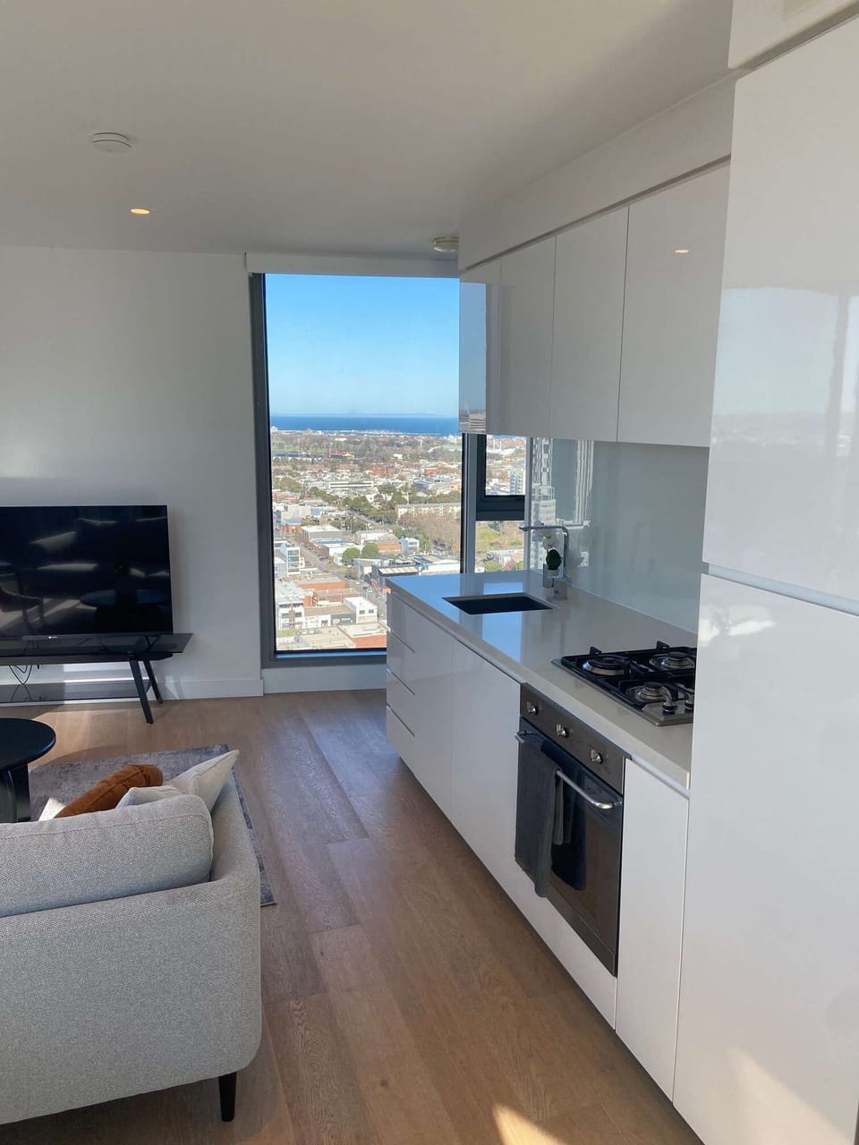Water View from large window in the lounge area: Light filled open plan living space with Kitchen, lounge and dining space: SMART TV, dining table, relaxing sofas and private balcony
