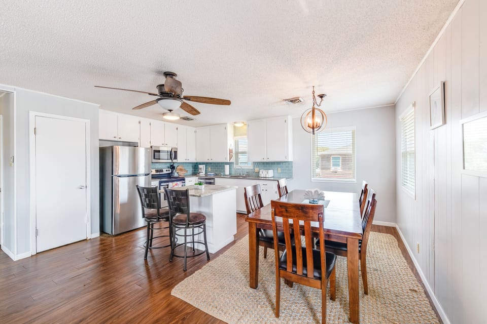 Your bright open kitchen flows seamlessly into the dining area, where warm wood floors and stylish lighting create the perfect space for memorable meals together.