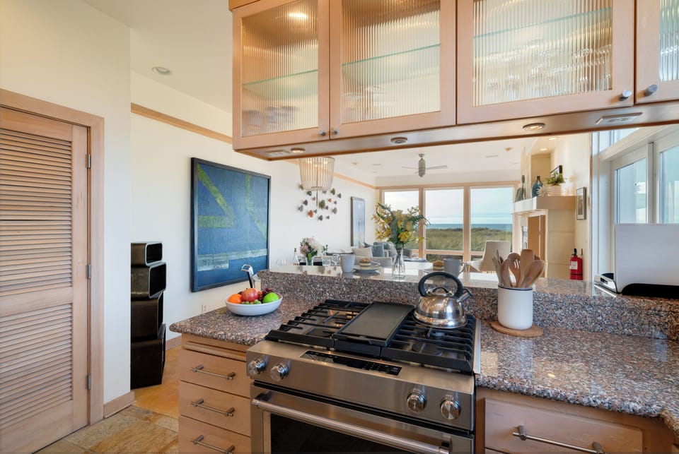 Ocean view fully equipped kitchen with breakfast bar, gas range, dishwasher, full fridge and microwave.