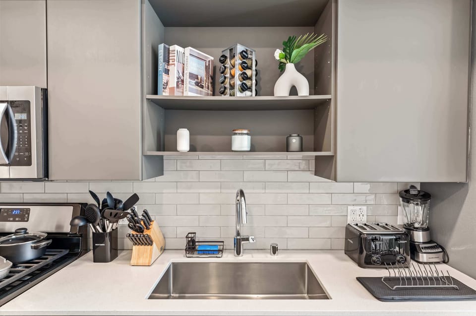Designer kitchen with modern cabinetry, elegant tile backsplash, and all essentials for inspired cooking.
