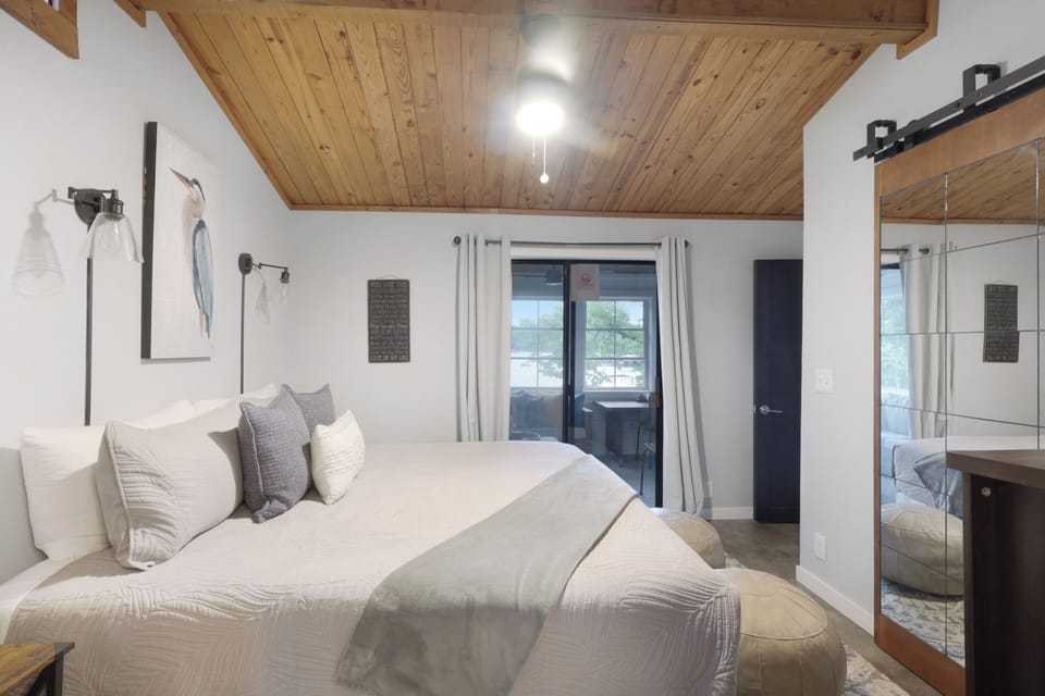 Drift into a peaceful night's sleep under soaring wood-paneled ceilings, with plush linens inviting you to unwind and your own private hot tub awaiting just beyond those doors.
