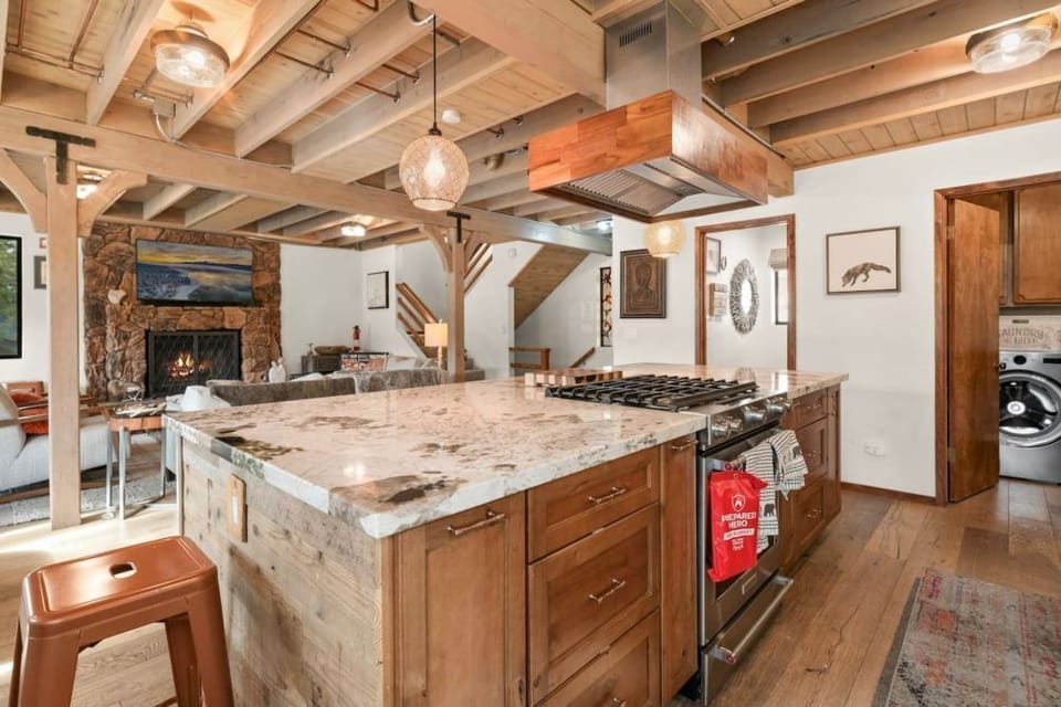 "Gather in our spacious kitchen and living area, where modern elegance meets rustic charm under exposed beams.