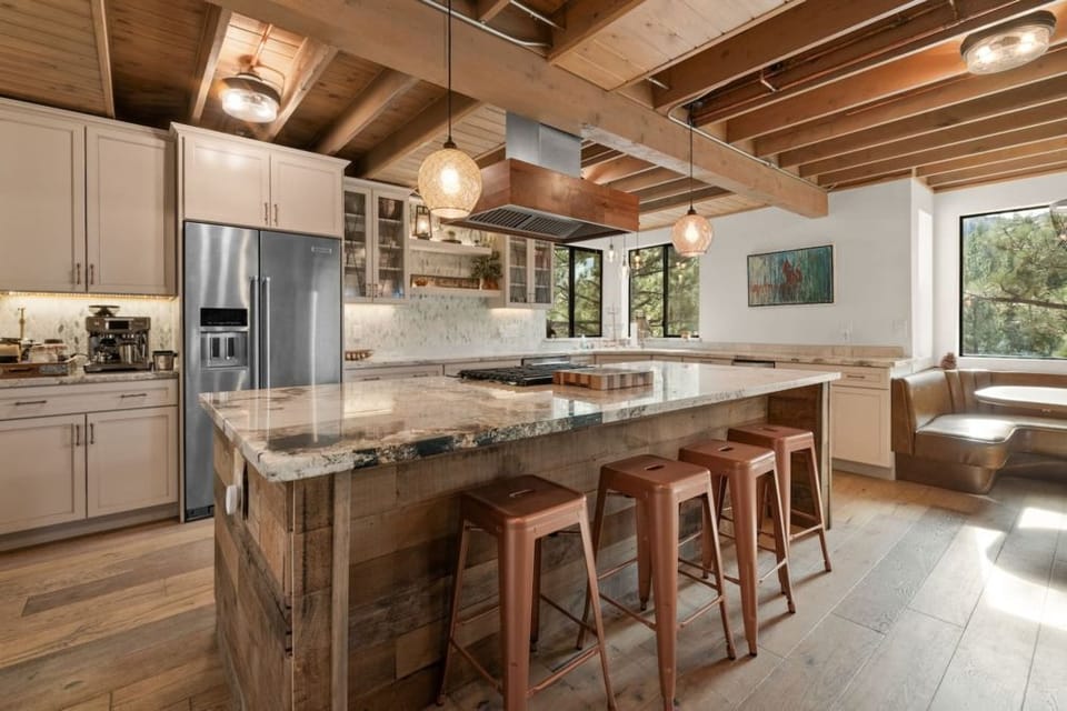 "Gather in our spacious kitchen and living area, where modern elegance meets rustic charm under exposed beams.