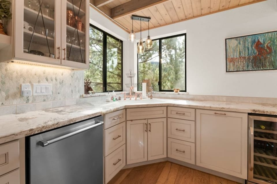 "Gather in our spacious kitchen and living area, where modern elegance meets rustic charm under exposed beams.