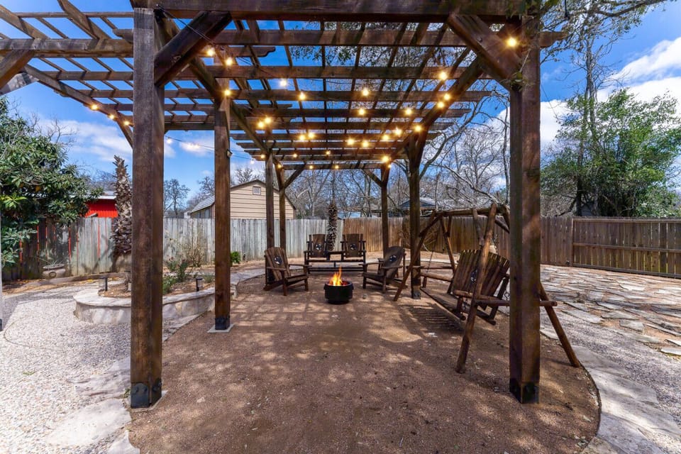 Cozy outdoor seating with pergola, swing, and firepit.