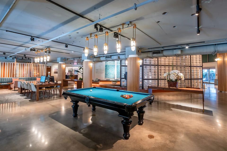 Challenge friends to a game of pool under modern lighting.