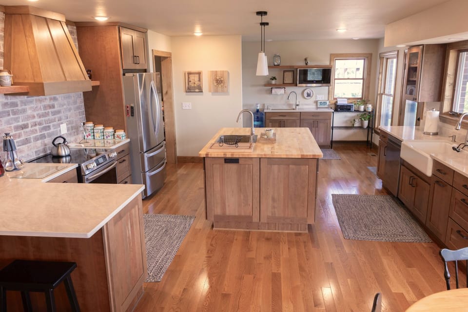 Farmhouse kitchen with countertop seating, center island, and scullery